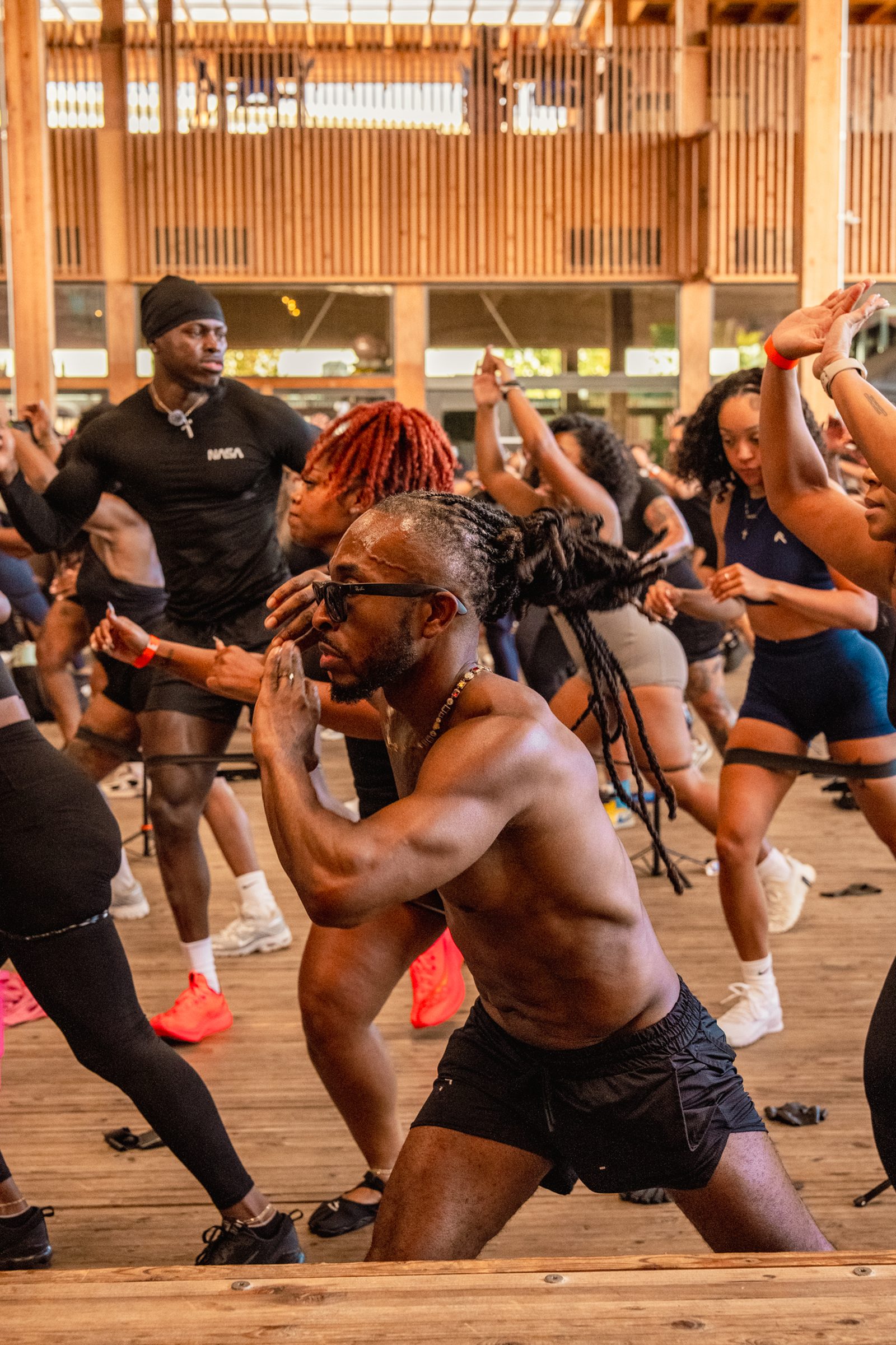 A shirtless instructor leading squats in the crowd