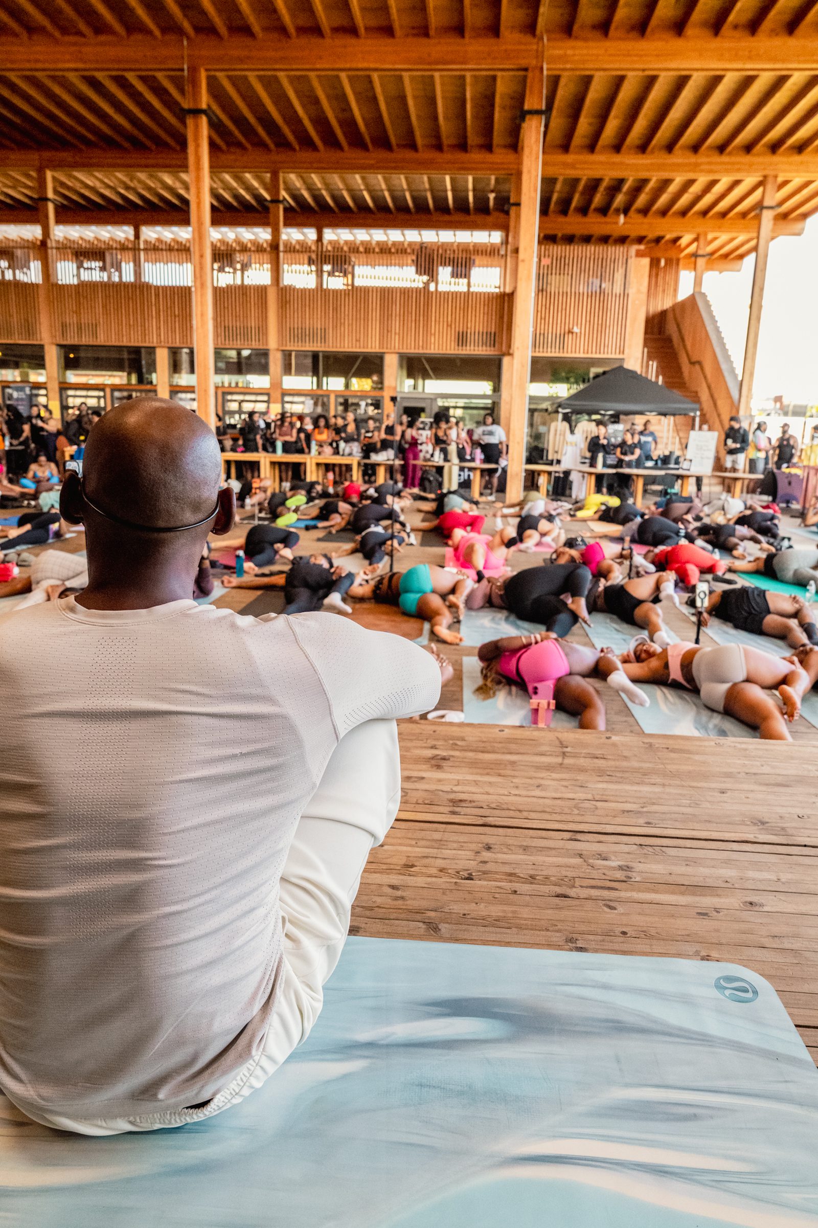 Instructor seated at the front, class in savasana behind