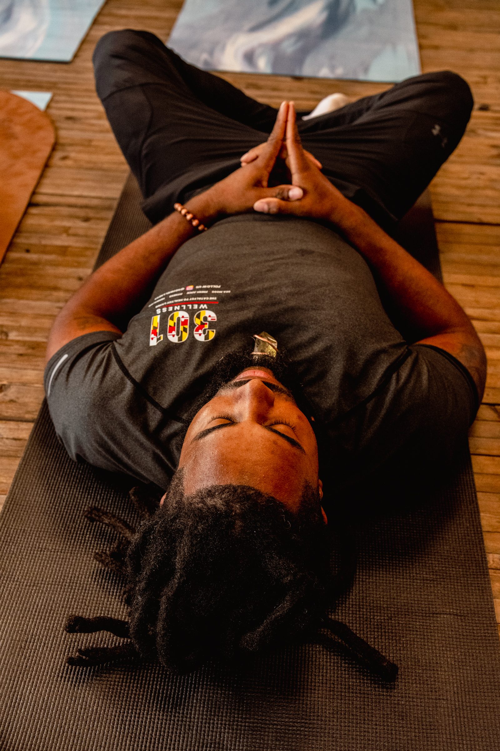 Overhead of a participant resting on the mat, Maryland shirt