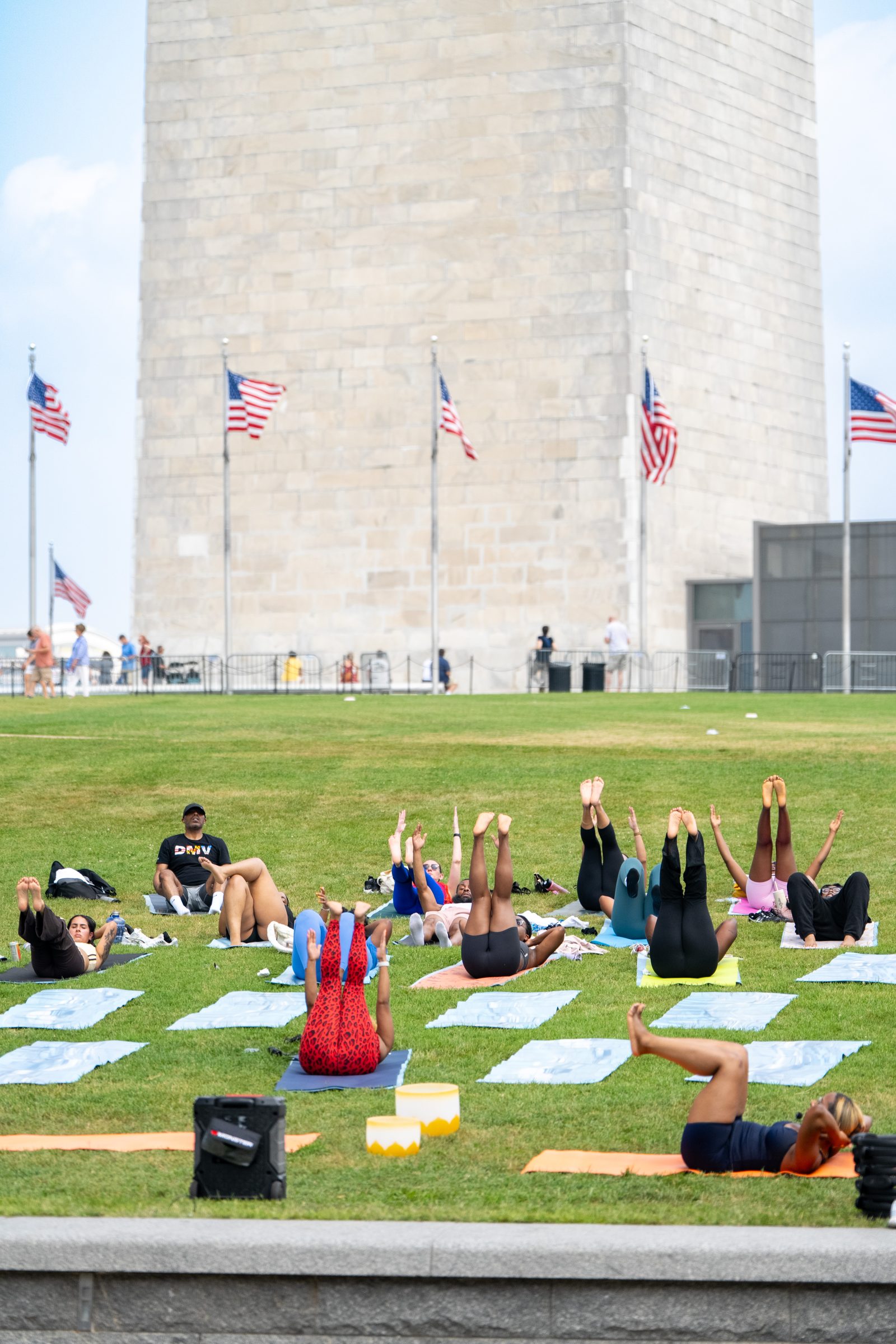 Wide view of the class with legs raised, monument towering behind