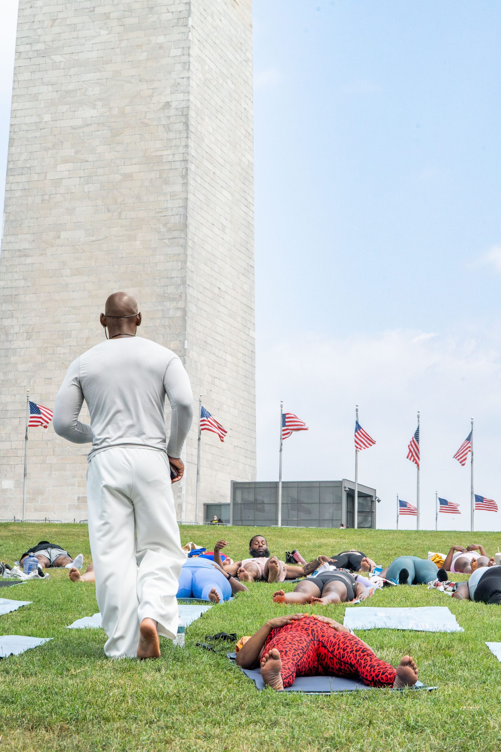 Instructor in white walking through the class, monument behind