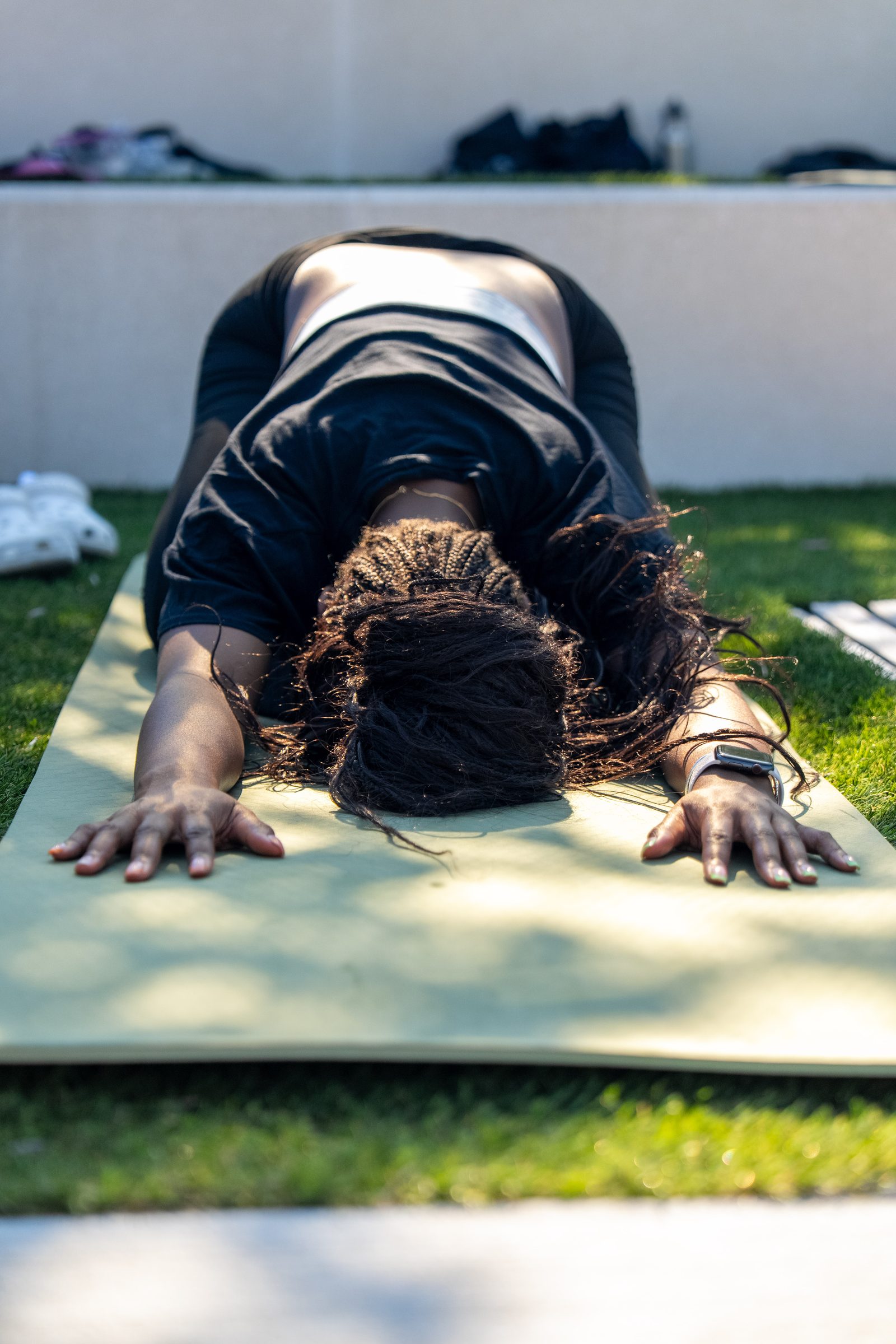 A participant resting in child's pose in dappled morning light