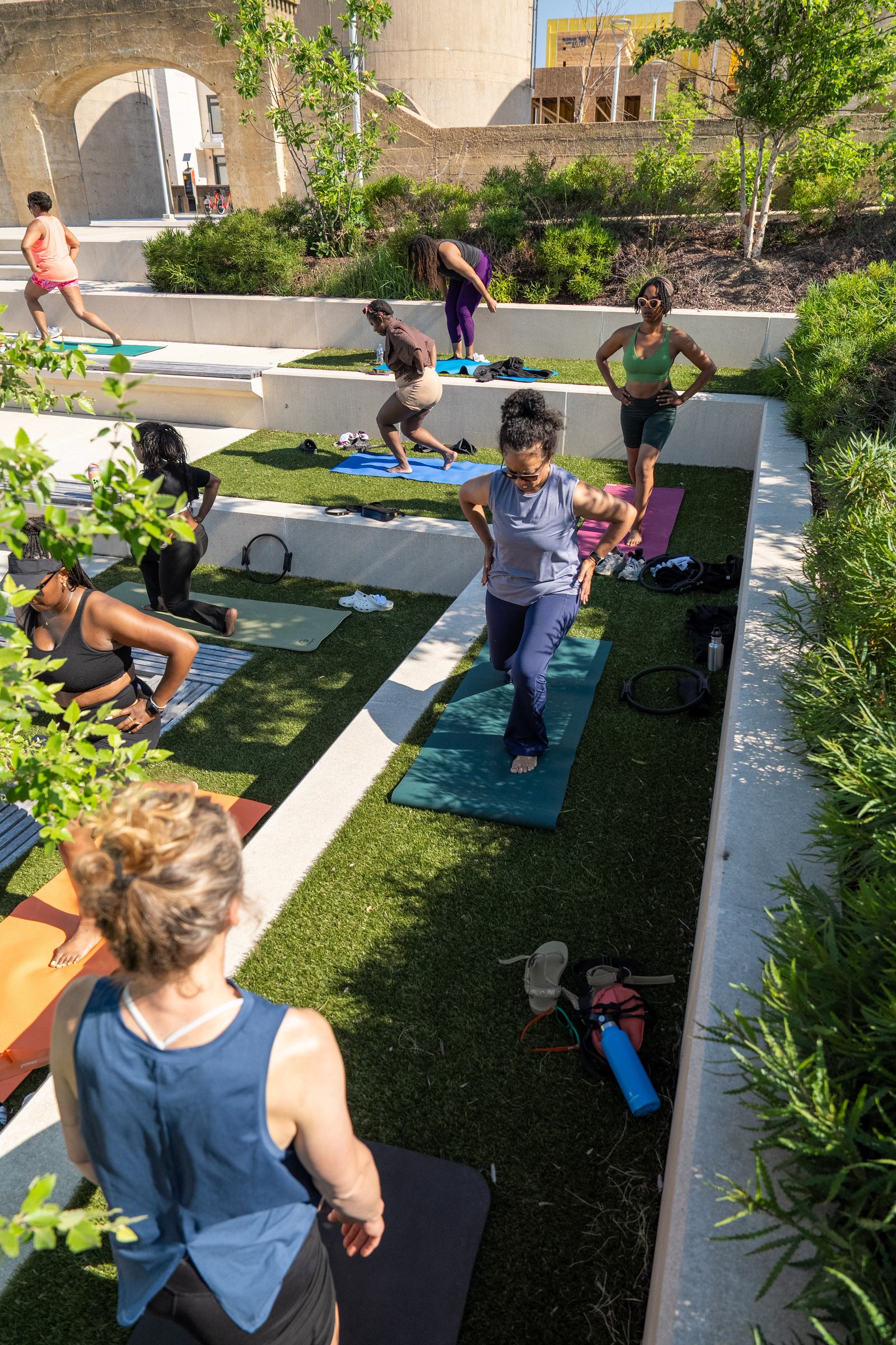 Overhead of the class doing standing lunges across the grass terrace