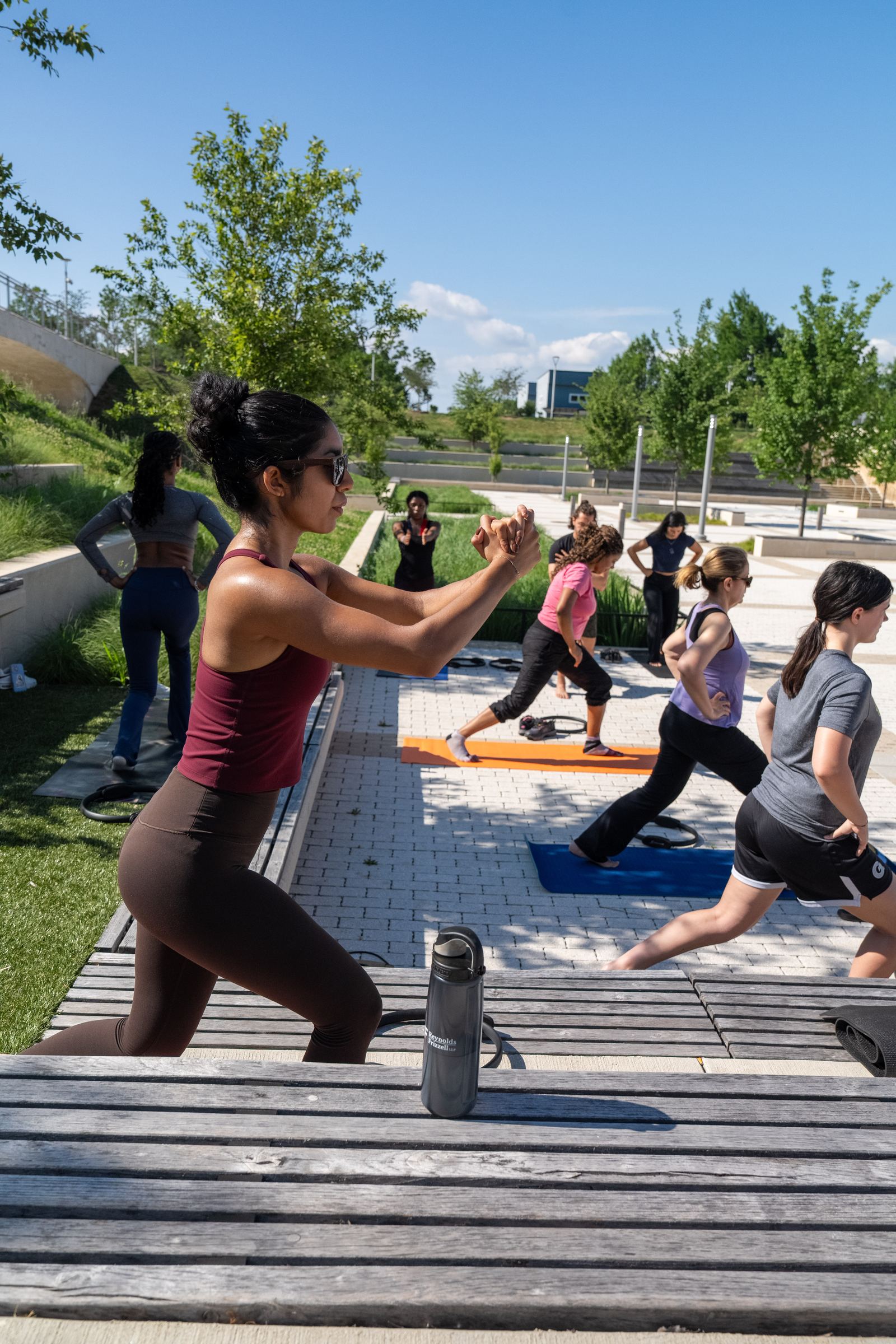 Participant in a low lunge with the full class practicing behind her