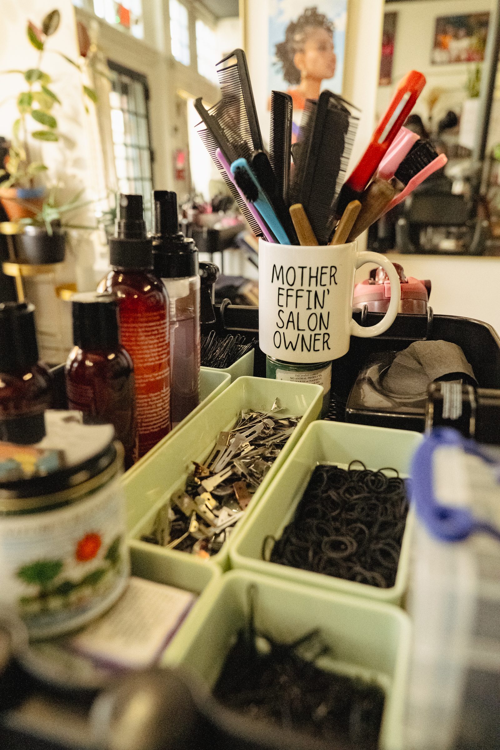 Combs, tools, and a mug reading "Mother Effin' Salon Owner"