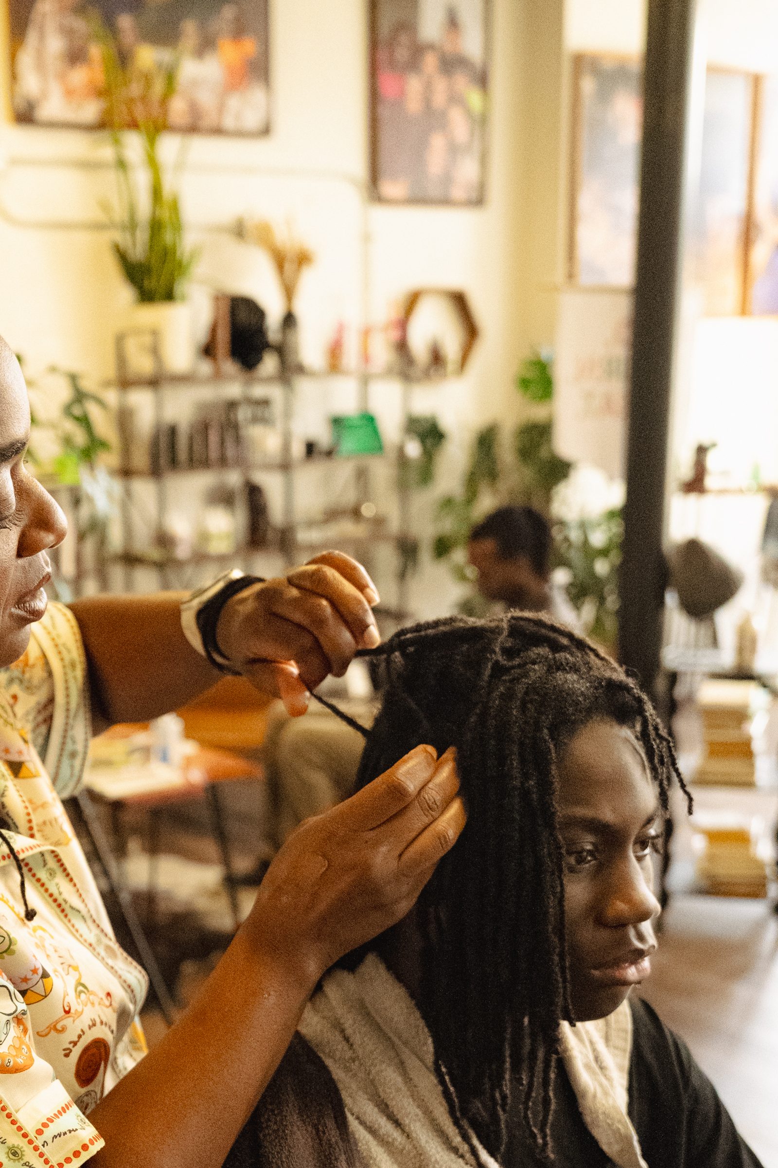 Stylist's hands retwisting a client's locs