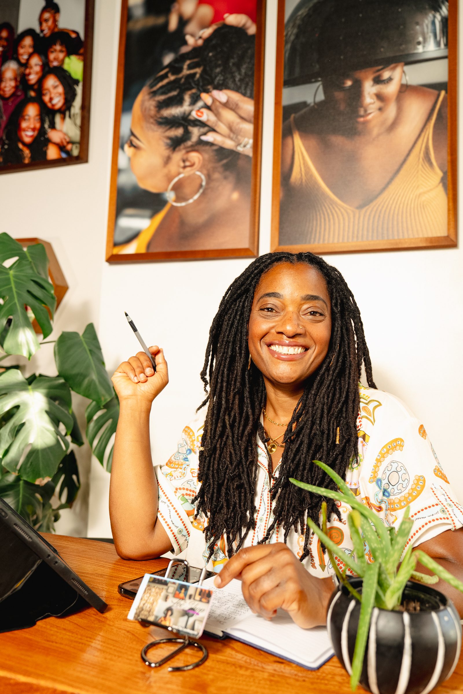 The salon owner at her desk, mid-laugh, pen in hand